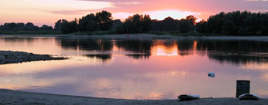 Urlaubsregion Höhbeck Elbe - Titelbild: Elbe rot gefärbt von der untergehenden Sonne, die sich im Wasser spiegelt. Am Strand liegen zwei Surfbretter.